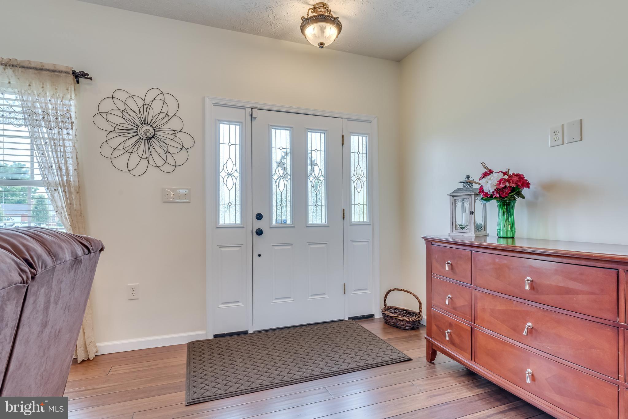 Bright foyer welcomes you in w/ hardwood floors