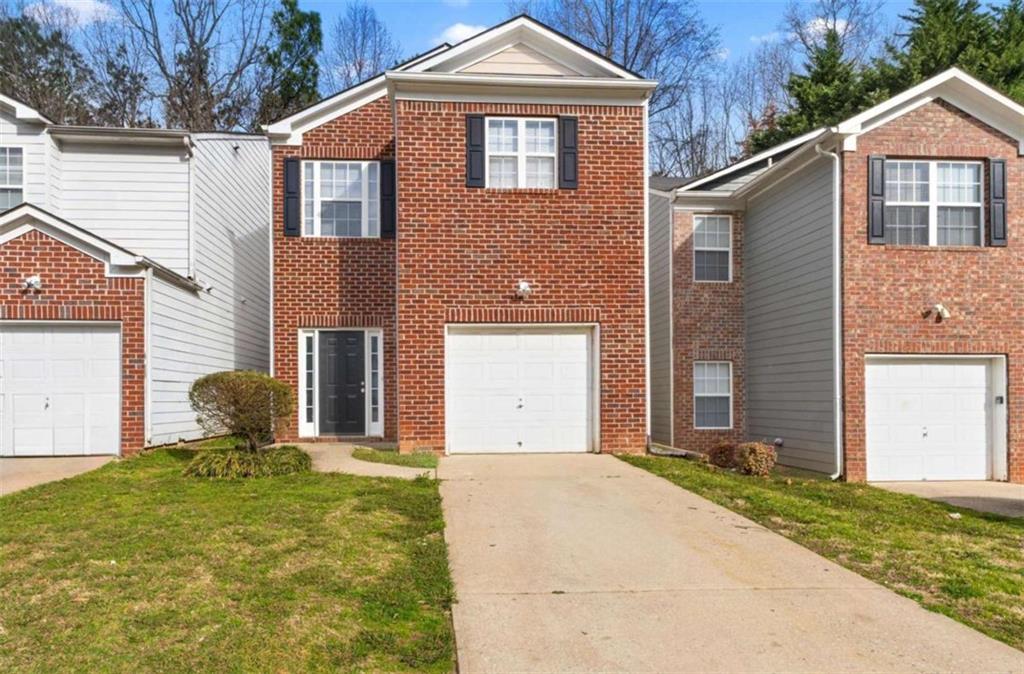 2825 Windsor Forrest Court Atlanta, GA 30349 - Photo 1 of 1 a front view of a house with a yard and garage
