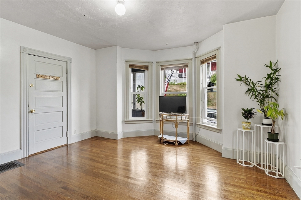 73 Dearborn Avenue, Unit 1 Lynn, MA 01905 - Photo 2 of 16 a view of a livingroom with wooden floor and a flat screen tv