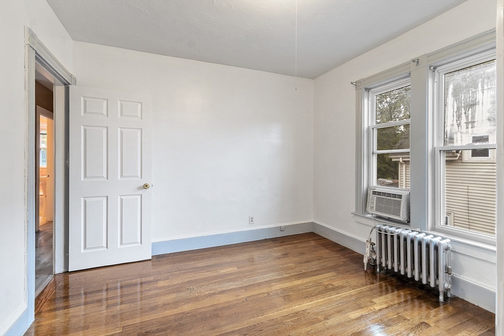 73 Dearborn Avenue, Unit 1 Lynn, MA 01905 - Photo 7 of 16 an empty room with wooden floor and windows
