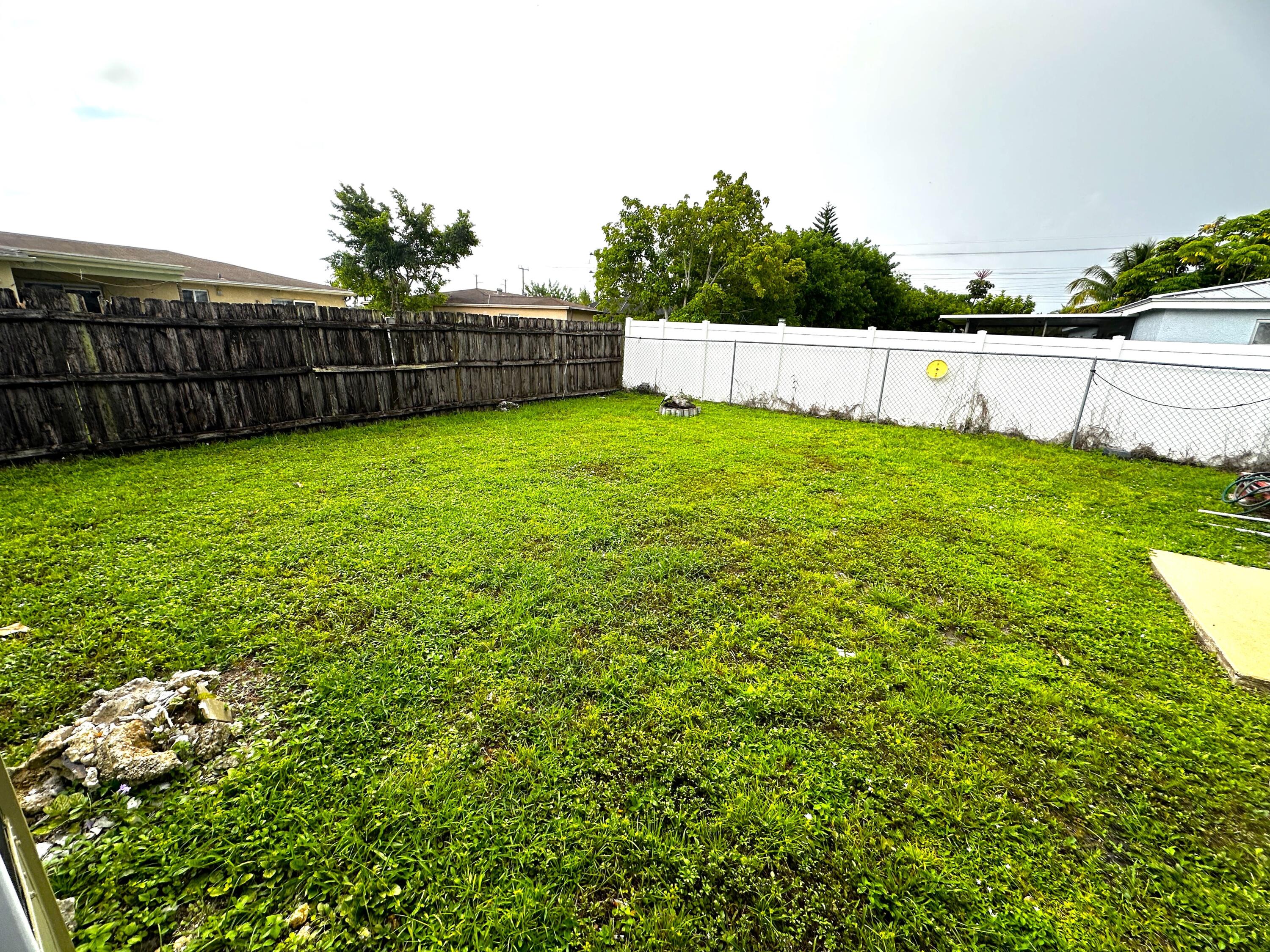 11150 Delta Circle Boca Raton, FL 33428 - Photo 16 of 17 a view of yard with swimming pool and wooden fence