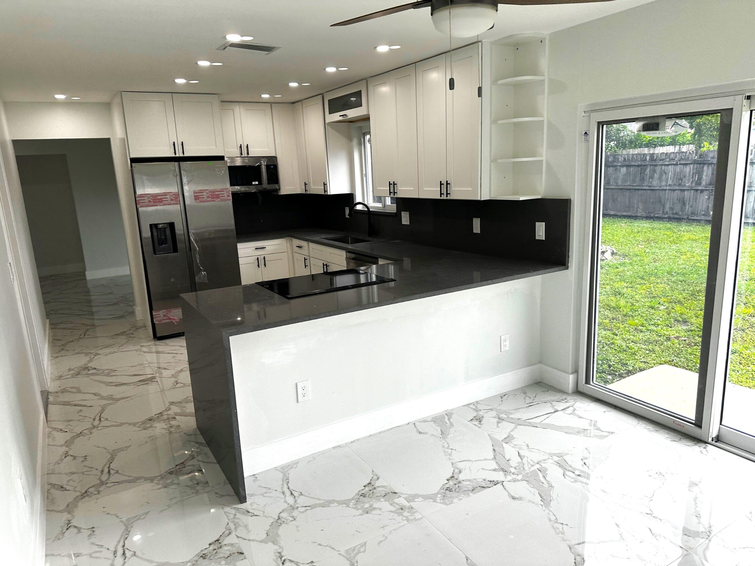 11150 Delta Circle Boca Raton, FL 33428 - Photo 2 of 17 a large white kitchen with a large window