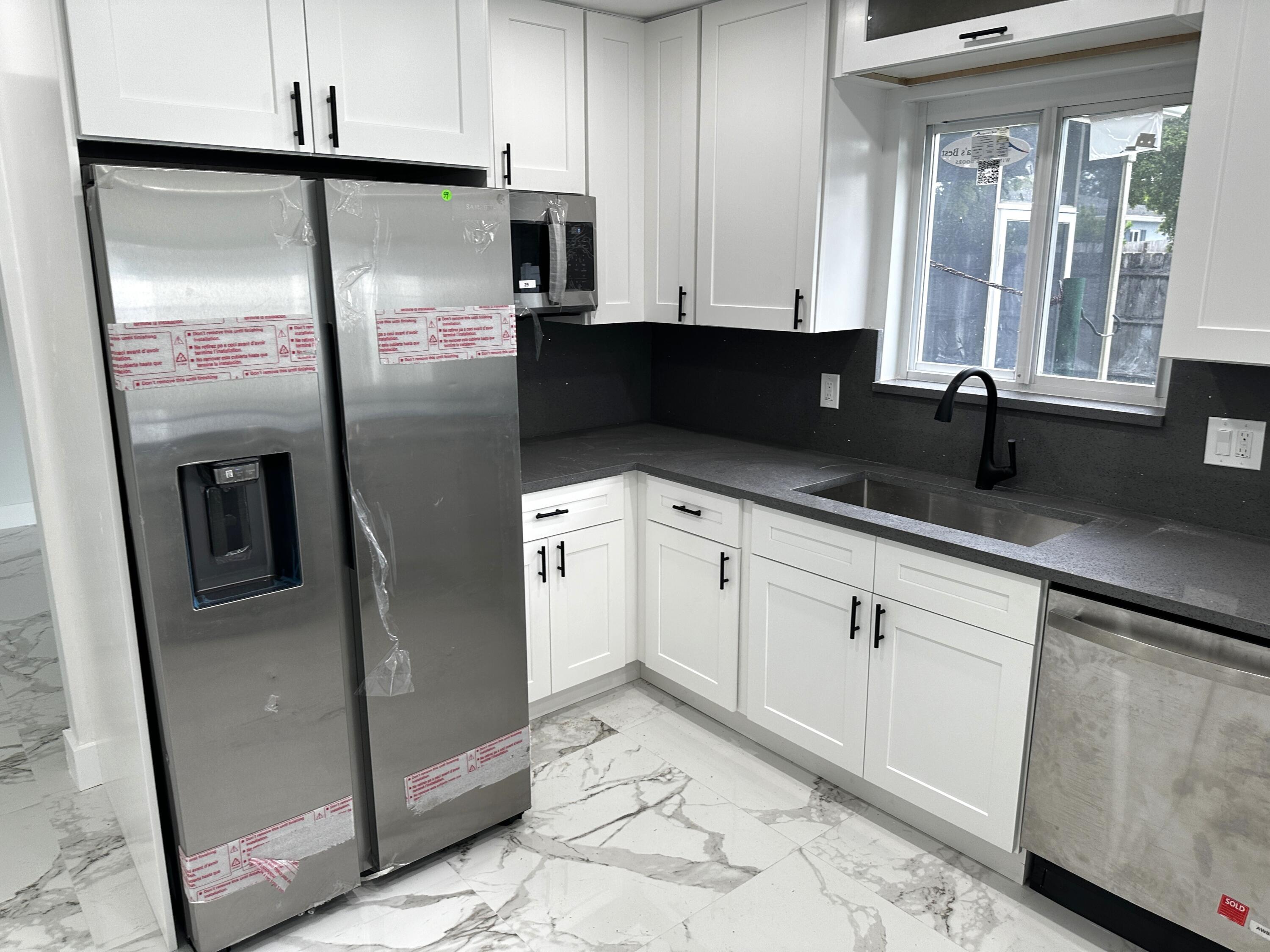 11150 Delta Circle Boca Raton, FL 33428 - Photo 4 of 17 a kitchen with stainless steel appliances granite countertop a refrigerator a sink and white cabinets