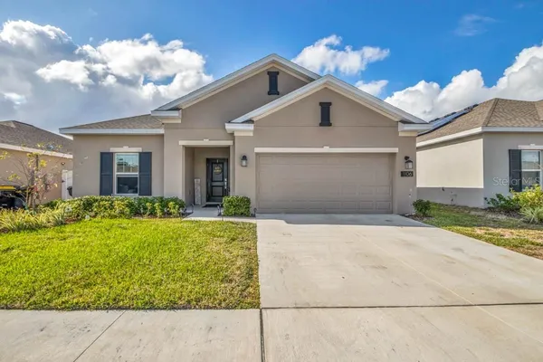 a view of a white house next to a yard