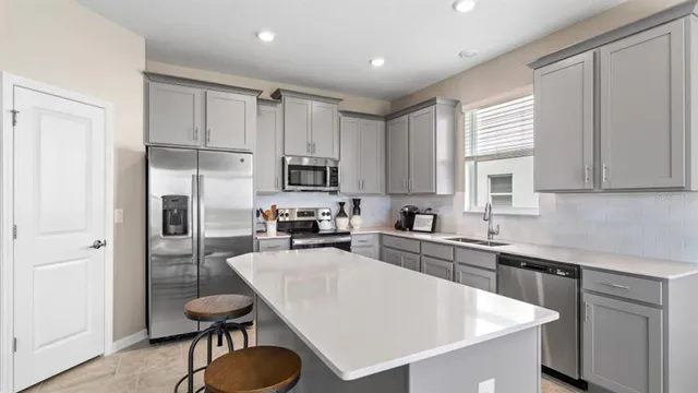 a kitchen with white cabinets and stainless steel appliances