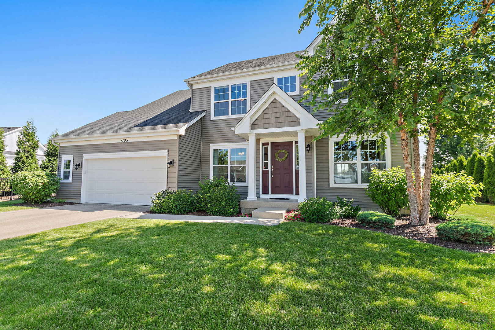 a front view of a house with a yard and garage