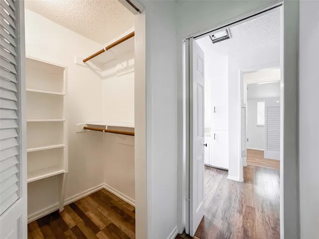 a view of walk in closet with empty racks