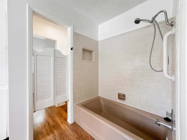 a bathroom with a tub shower and a sink
