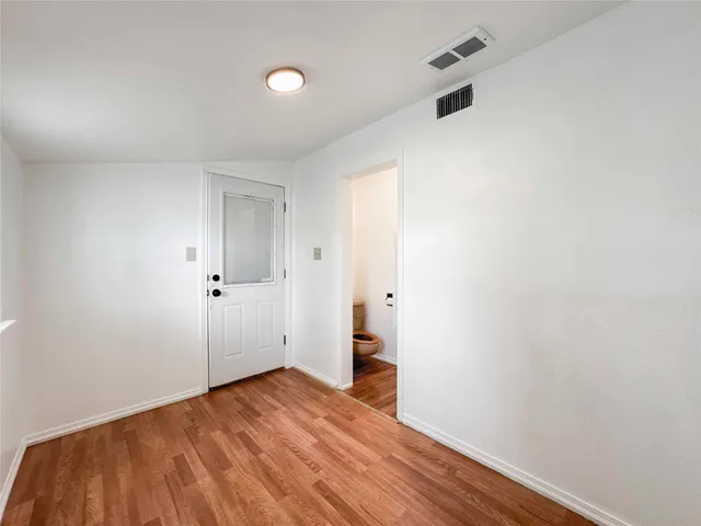 a view of an empty room with wooden floor