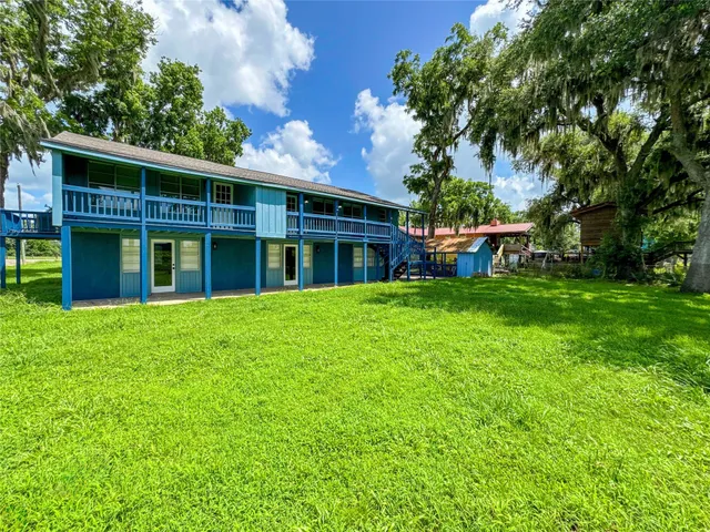 a view of an house with backyard space and balcony