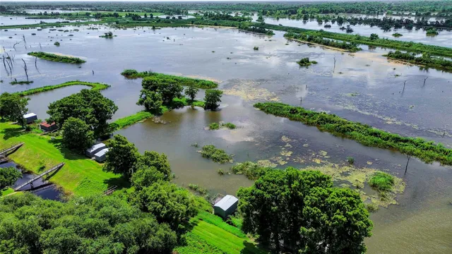 an aerial view of a house with a yard and lake view