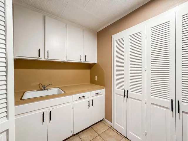 a kitchen with white cabinets and white appliances