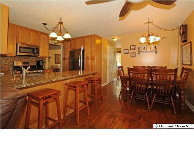 10 Capitol Reef Road Howell, NJ 07731 - Photo 3 of 3 a kitchen with stainless steel appliances kitchen island granite countertop a table chairs and a chandelier