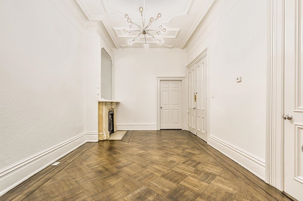 118 Mercer Street Jersey City, NJ 07302 - Photo 11 of 33 an empty room with chandelier fan and windows