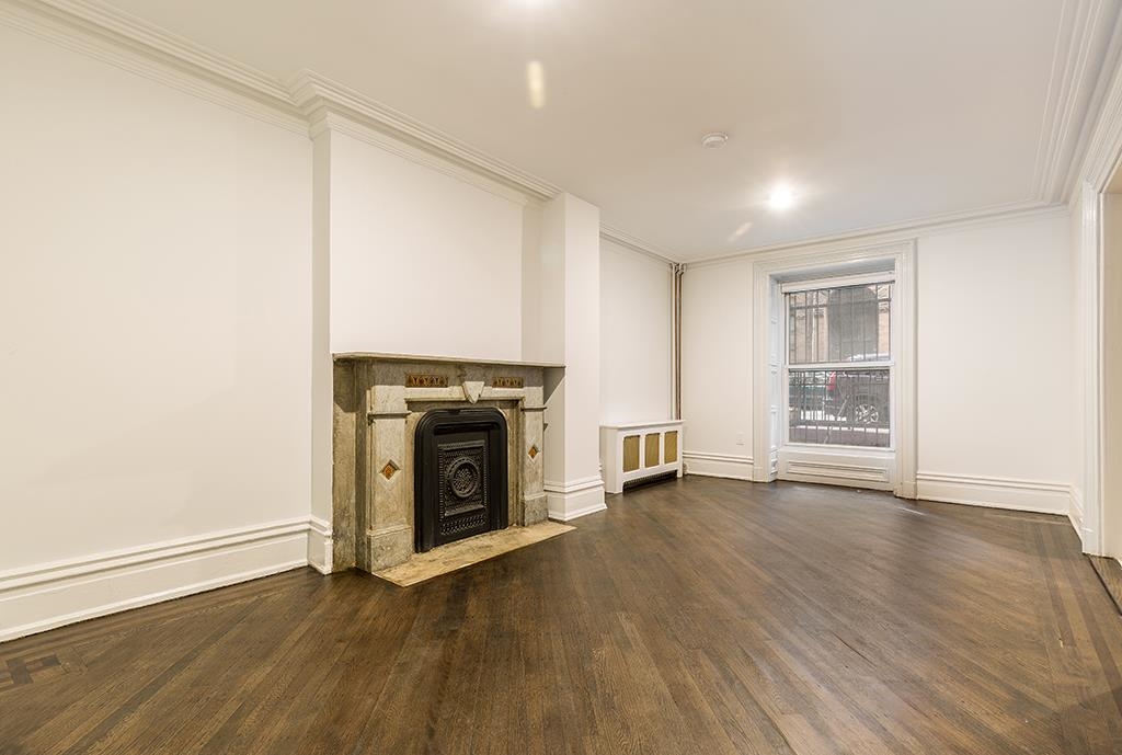 118 Mercer Street Jersey City, NJ 07302 - Photo 16 of 33 a view of an empty room with wooden floor fireplace and a window