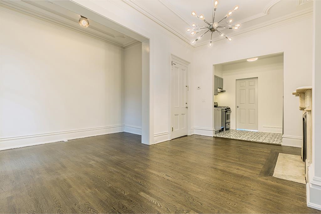 118 Mercer Street Jersey City, NJ 07302 - Photo 25 of 33 an empty room with wooden floor and ceiling fan