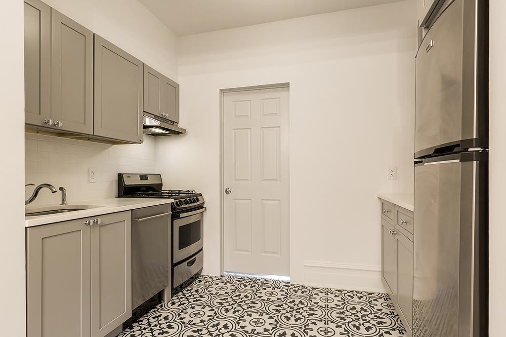 118 Mercer Street Jersey City, NJ 07302 - Photo 26 of 33 a kitchen with a sink a refrigerator freezer and a stove