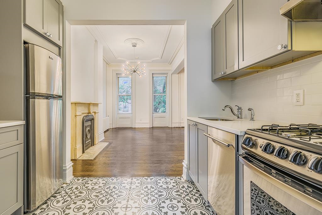 118 Mercer Street Jersey City, NJ 07302 - Photo 27 of 33 a kitchen with stainless steel appliances granite countertop a refrigerator a stove and a sink with cabinets
