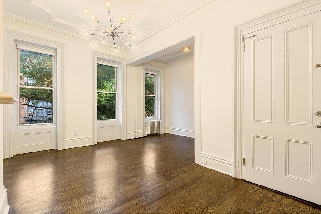118 Mercer Street Jersey City, NJ 07302 - Photo 28 of 33 an empty room with wooden floor fan and windows