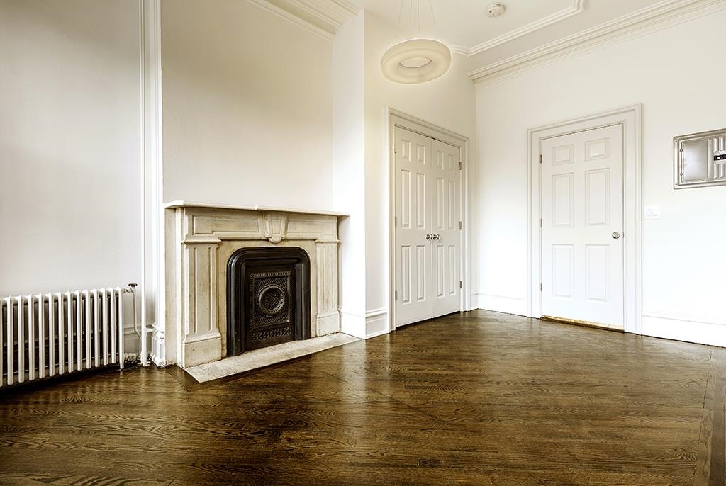 118 Mercer Street Jersey City, NJ 07302 - Photo 31 of 33 a view of an empty room with wooden floor and a fireplace