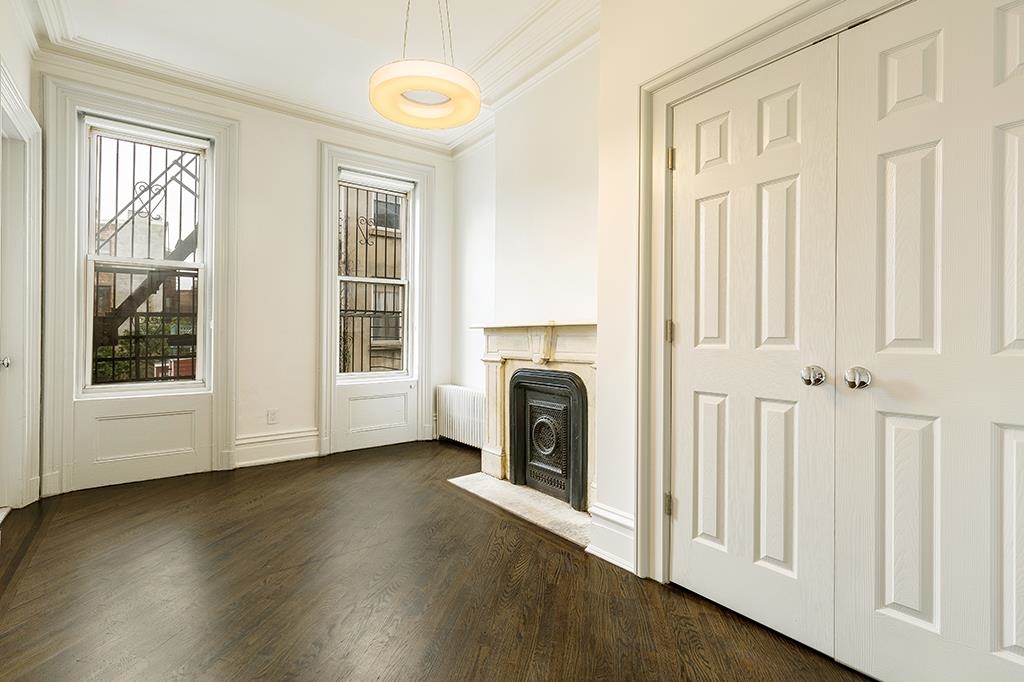 118 Mercer Street Jersey City, NJ 07302 - Photo 32 of 33 a view of a livingroom with a fireplace wooden floor and windows