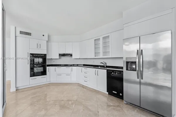 a kitchen with stainless steel appliances granite countertop a refrigerator and cabinets