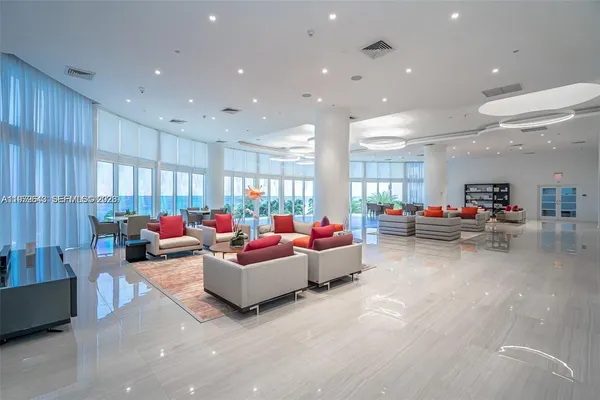 a living room with furniture and floor to ceiling window