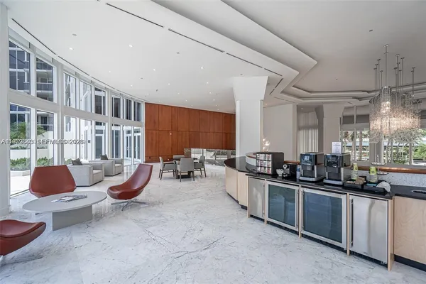 a view of a room with lots of wooden furniture and floor to ceiling windows
