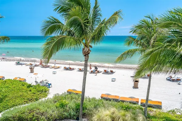 a large white kitchen with a large window and stainless steel appliances