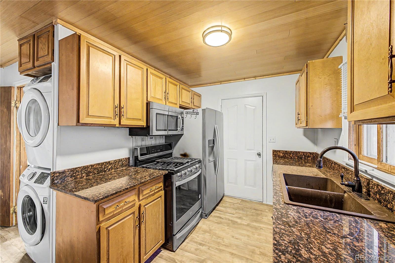145 Bailey Drive Bailey, CO 80421 - Photo 10 of 31 a kitchen with stainless steel appliances granite countertop a stove a sink and a microwave
