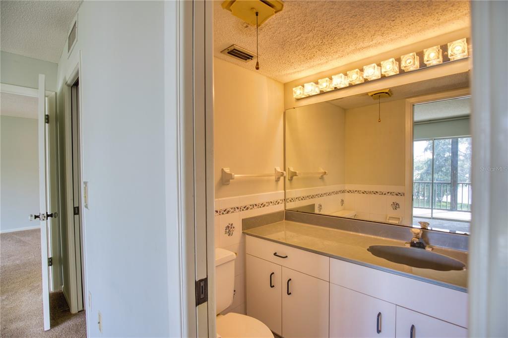 102 Capri Isles Boulevard, Unit 207 Venice, FL 34292 - Photo 15 of 25 a bathroom with a granite countertop sink mirror and a bathtub
