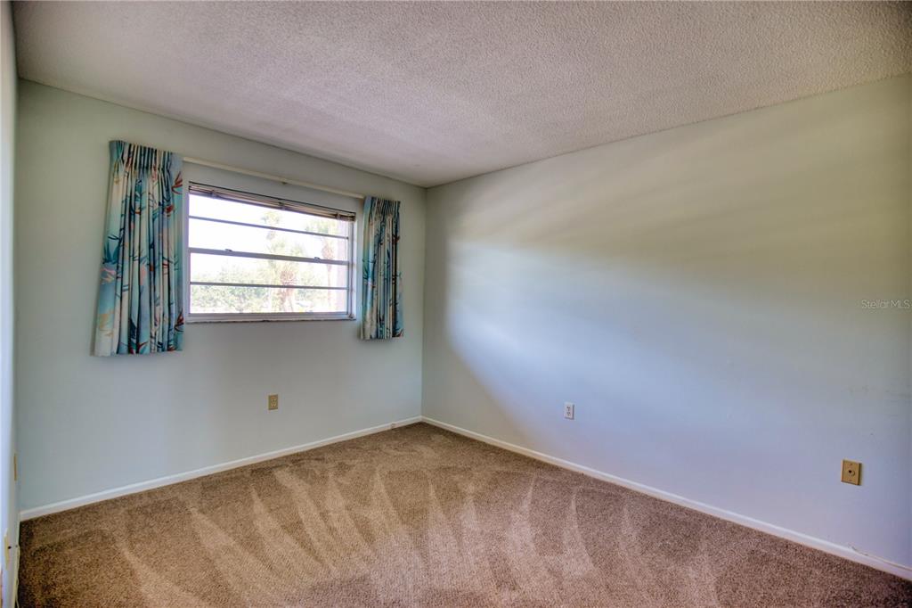 102 Capri Isles Boulevard, Unit 207 Venice, FL 34292 - Photo 18 of 25 an empty room with windows