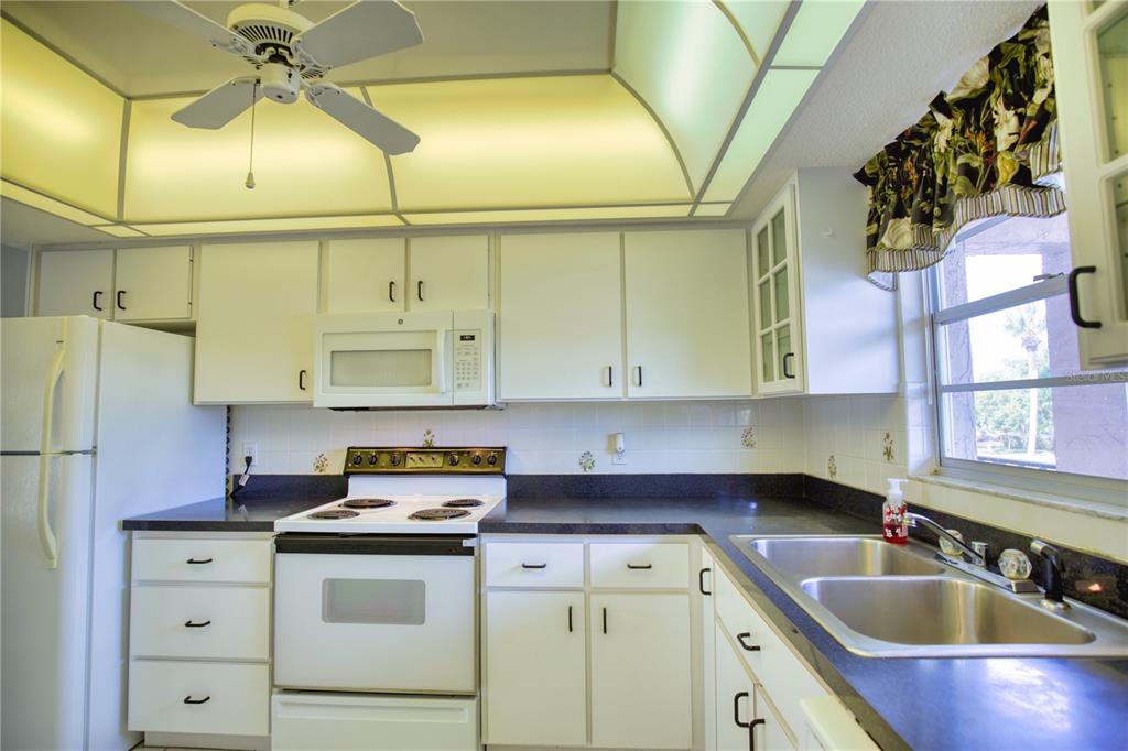 102 Capri Isles Boulevard, Unit 207 Venice, FL 34292 - Photo 8 of 25 a kitchen with cabinets a sink and appliances