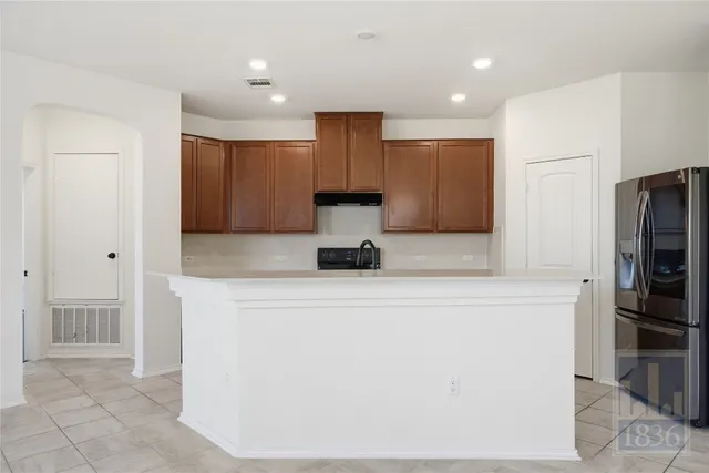 a kitchen with a refrigerator and a stove