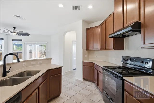 a kitchen with stainless steel appliances granite countertop a sink stove and cabinets