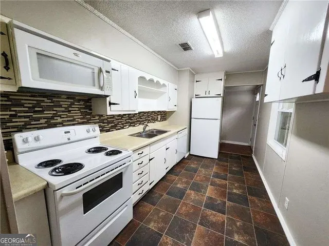 a kitchen with a stove a sink and a refrigerator