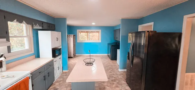 a kitchen with stainless steel appliances granite countertop a refrigerator a stove and a sink