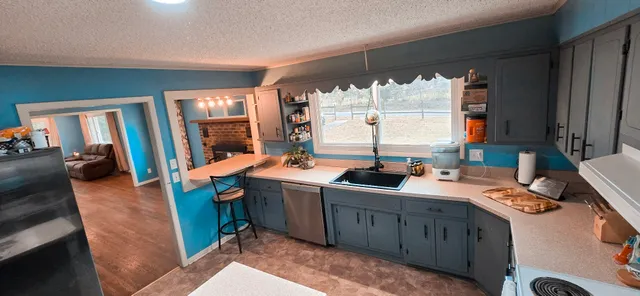 a view of a kitchen with sink and window