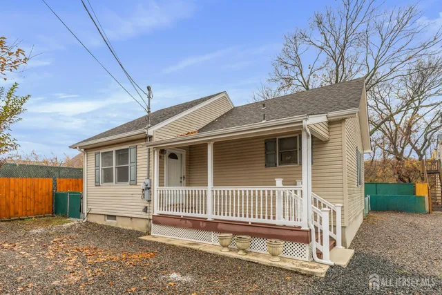 a view of a house with a yard and wooden fence