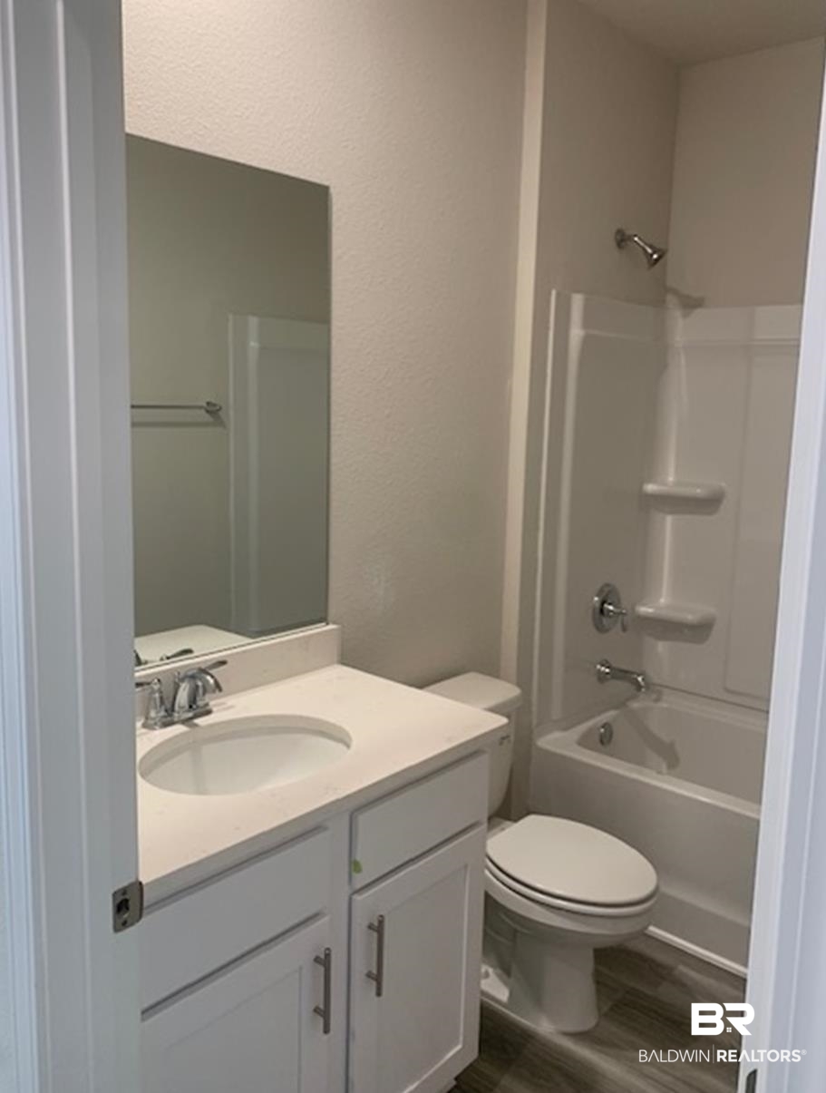 12904 Grand Rpds Road Fairhope, AL 36532 - Photo 26 of 34 Full bathroom featuring vanity, shower / tub combination, toilet, and wood-type flooring