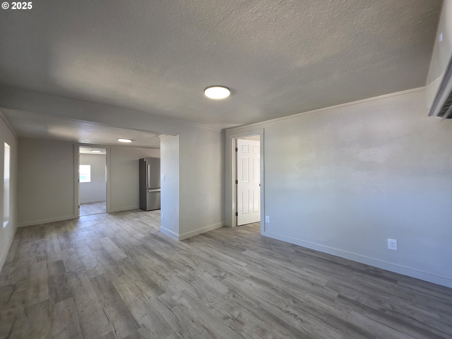 510 Boyer Road Riddle, OR 97469 - Photo 11 of 31 an empty room with wooden floor and windows