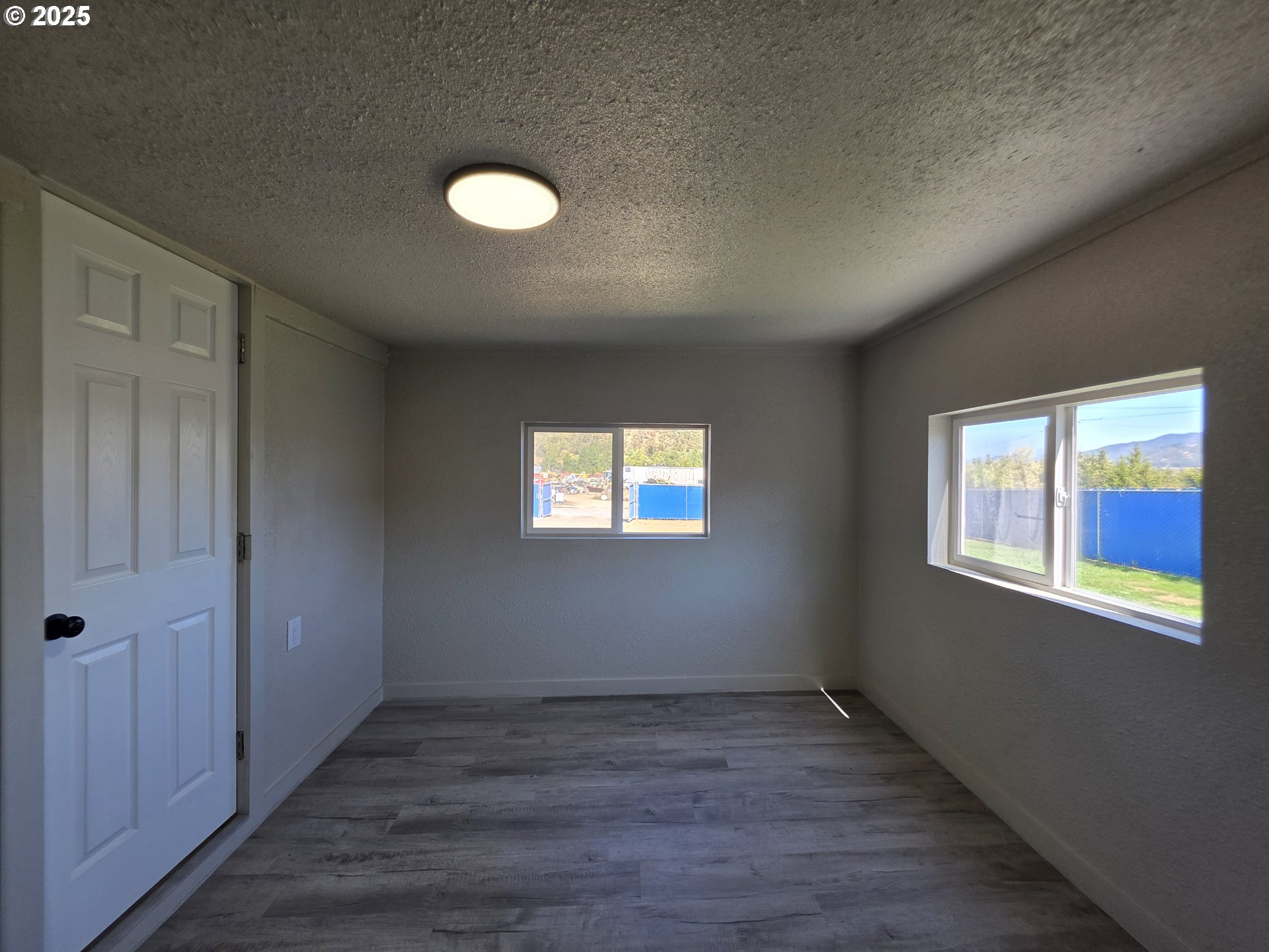 510 Boyer Road Riddle, OR 97469 - Photo 23 of 31 an empty room with wooden floor and windows