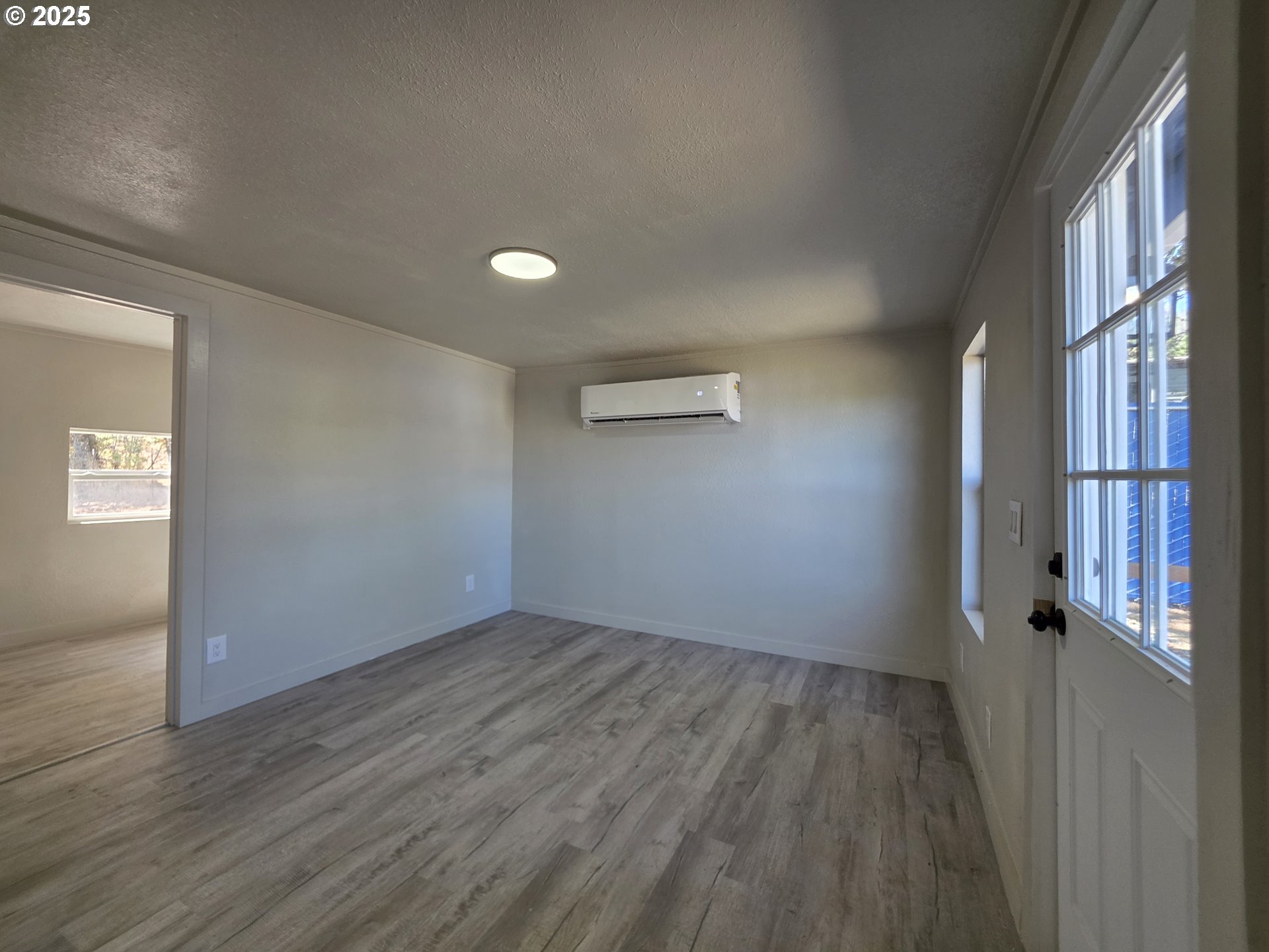 510 Boyer Road Riddle, OR 97469 - Photo 10 of 31 an empty room with wooden floor and windows