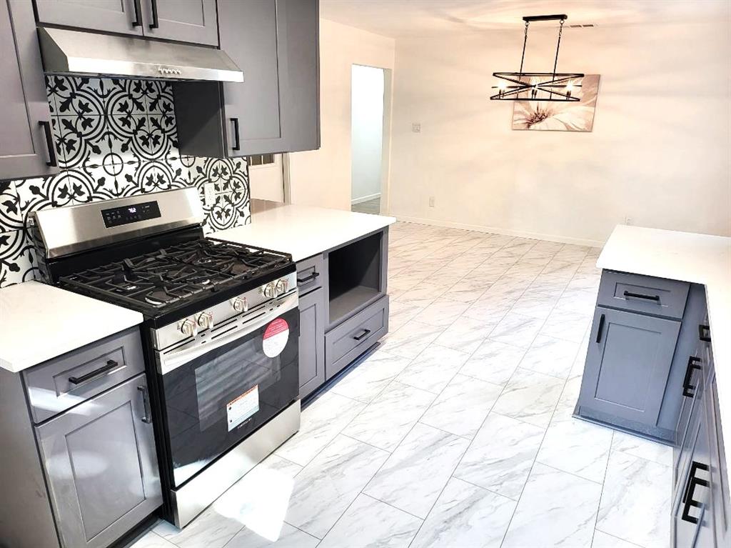 412 Ellis Street Allen, TX 75002 - Photo 5 of 36 a kitchen with granite countertop a stove a sink and a microwave