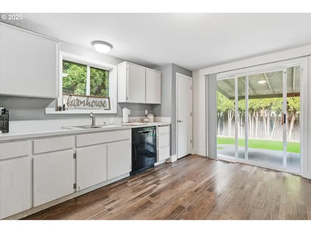 a kitchen that has a lot of cabinets and wooden floor