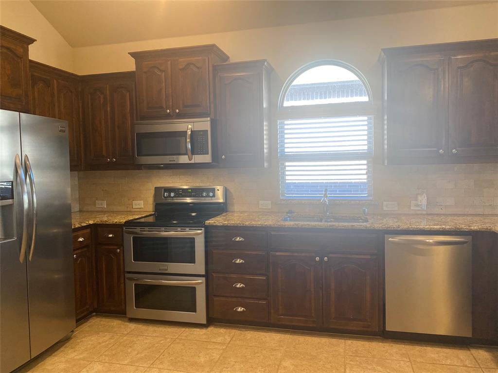 1220 Scott Drive Weatherford, TX 76087 - Photo 11 of 35 Whether alone or with people, cozy kitchen with double oven, refrigerator, dishwasher and disposal makes life easier to cook, bake or entertain.