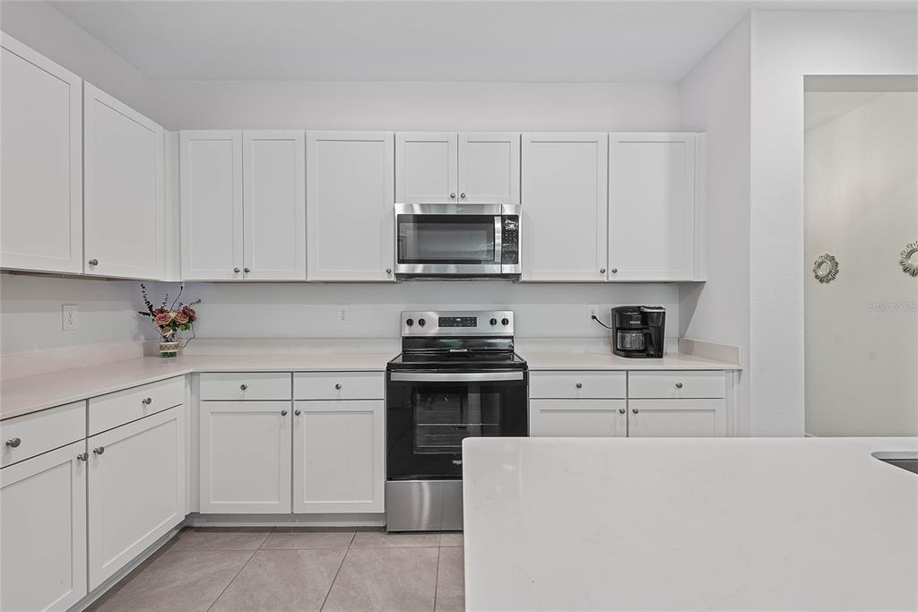 309 Redbud Road Palm Coast, FL 32137 - Photo 11 of 33 a kitchen with cabinets appliances a sink and a counter space