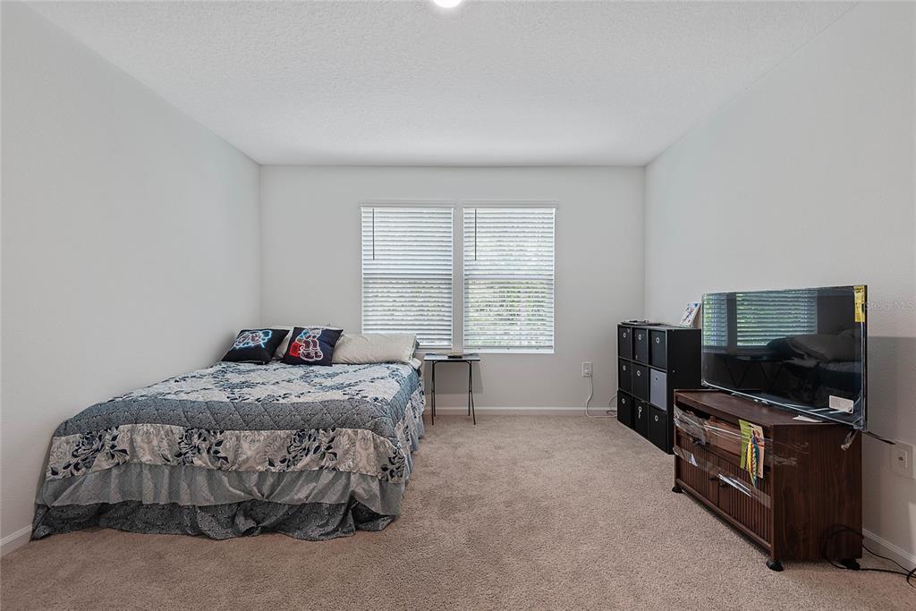 309 Redbud Road Palm Coast, FL 32137 - Photo 19 of 33 a bedroom with a bed and furniture