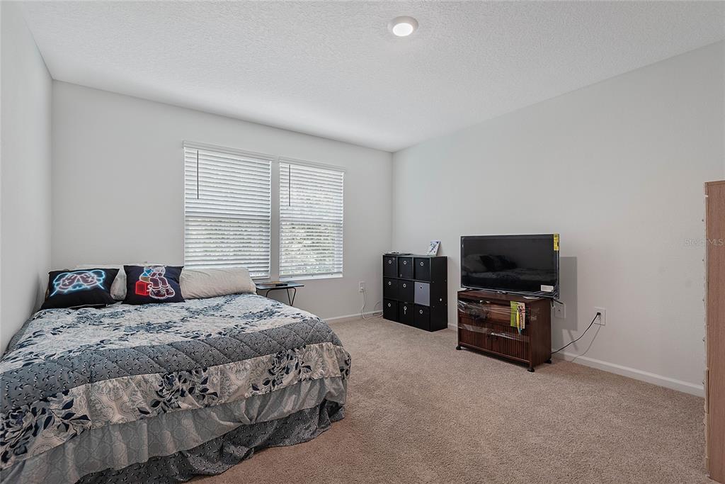 309 Redbud Road Palm Coast, FL 32137 - Photo 20 of 33 a bedroom with a bed and a television