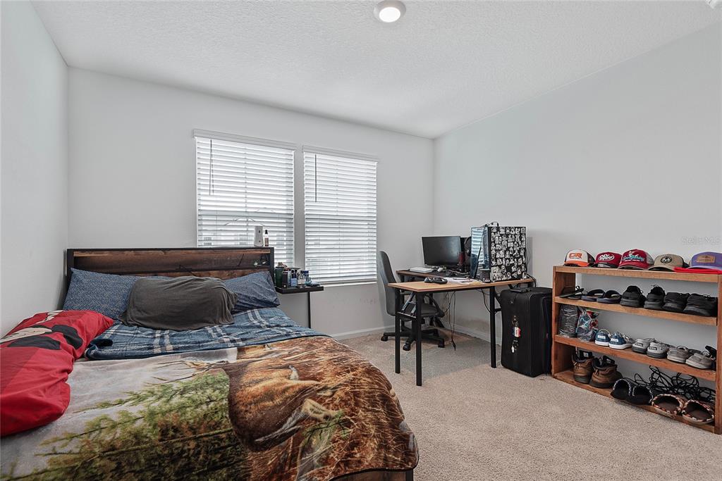 309 Redbud Road Palm Coast, FL 32137 - Photo 27 of 33 a bedroom with a bed and a desk